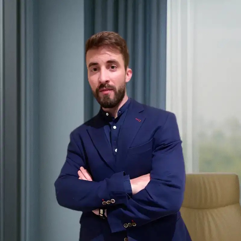 Juan Casanova, cofundador de Nomadic Closer Academy, con chaqueta azul marino y brazos cruzados
