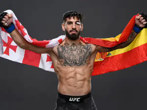 💭 Cómo pensar en grande en 2025: mentalidad de campeón para triunfar online 🚀 Ilia Topuria con las banderas de Georgia y España extendidas, mostrando actitud de campeón y disciplina mental