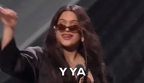 Rosalía levantando la mano en un gesto icónico durante una aparición pública, usada como ejemplo de estrategia de marketing en el artículo.