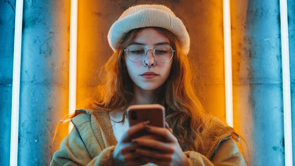 Joven mirando su móvil en TikTok, representando el auge de los vídeos cortos como nuevo buscador en el marketing digital 2025