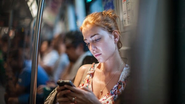 Qué negocio online montar en 2026 (y qué curso elegir sin perder dinero) Mujer joven consultando cursos online en su móvil mientras viaja en el metro